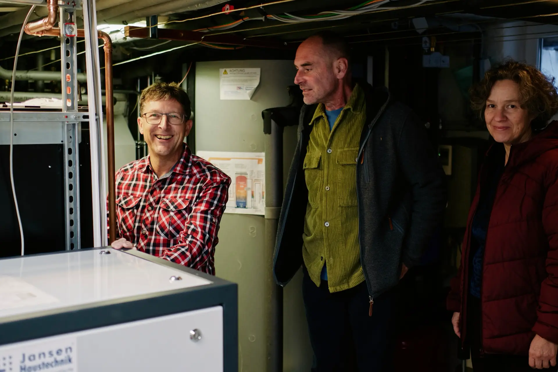 © Katharina Sellin / Greenpeace Frau zeigt einer Gruppe ihre Haustechnik (AI generated photo)